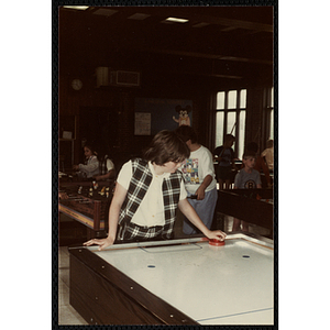 A girl plays air hockey