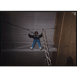 A girl walks on a rope in a gymnasium