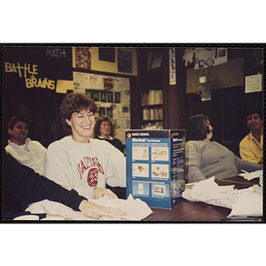 A staff member of the Charlestown Clubhouse seated at a table with an unwrapped gift