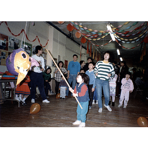 Guest swings at a piñata during the Chinese Progressive Association's children's party