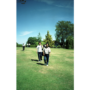 Two female Chinese Progressive Association members walk across a grassy field