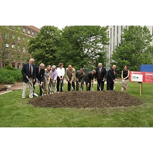 People stand with shovels prepared to break ground for the Veterans Memorial