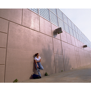 A student on a photography co-op leaning against Ruggles Station