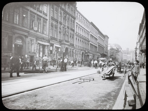 Laborers pave a street, location unknown
