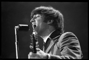 John Lennon at the microphone, in concert with the Beatles, Washington Coliseum