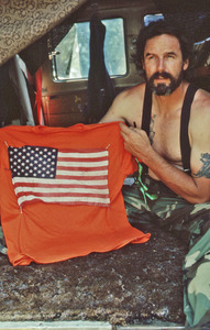 Gene Dorr holding an orange shirt with a flag
