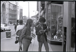 Free Spirit Press crew member (Charlie Ribokas) and young African American man looking at copy of the magazine on a street