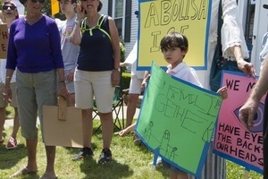 Young boy carrying a sign reading 'Keep families together' at a pro-immigration rally in front of the Chatham town offices building : taken at the 'Families Belong Together' protest against the Trump administration's immigration policies