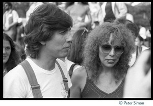 Graham Nash in overalls standing with Joni Mitchell at the No Nukes protest and concert