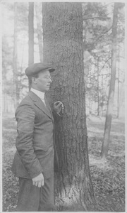 William J. Fahey, Jr. standing outdoors, leaning on tree