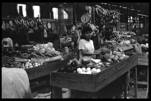 Woman operating a market stall in the old marketplace, selling fruit, Belize City