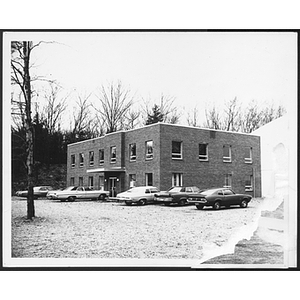 Line of cars parked in front of a two story building