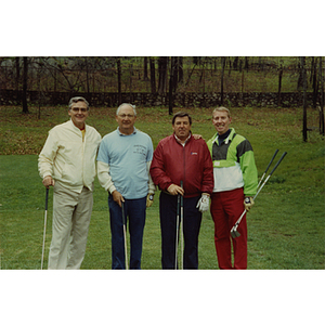 A four-man golf team posing on the golf course at a Boys & Girls Club Golf Tournament