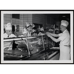 Members of the Tom Pappas Chefs' Club serve food in a Brandeis University dining hall