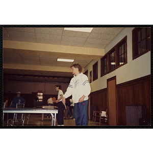 Teenage boys play table tennis in a hall