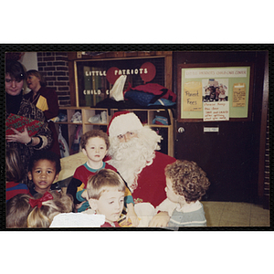 A group of children visit with Santa Claus at a Christmas event