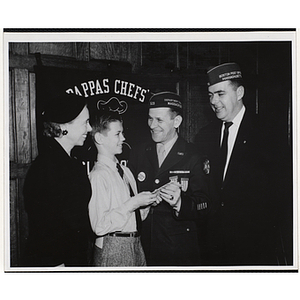 A boy poses with a veteran as a unidentified man and Barbara Sherman Burger (far left) look on a Tom Pappas Chefs' Club event