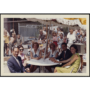 The panel of judges sitting under an umbrella during a Boys' Club Little Sister Contest