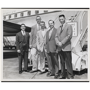 Five men posing in front of an airplane, including Paul F. Hellmuth, standing fourth from left