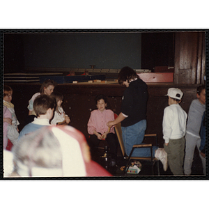 Several Boys & Girls Club members gather in front of the stage in an auditorium