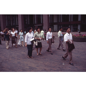 Visitors from China walk past City Hall Plaza on a tour of Boston