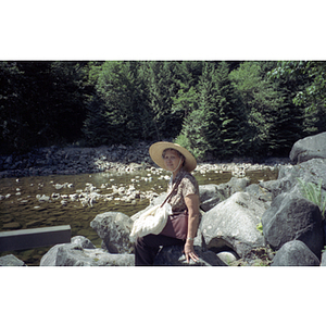 Woman sits on a rocky riverbed in a Vancouver park