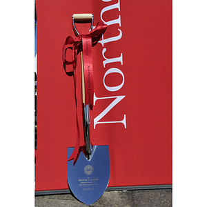 The ceremonial groundbreaking shovel for the George J. Kostas Research Institute for Homeland Security, located on the Burlington campus of Northeastern University stands against a Northeastern University banner