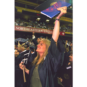 Graduates cheer after receiving their degrees during commencement