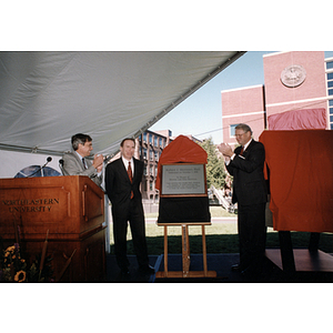 Richard Freeland, Robert Shillman, and Neal Finnegan stand around the plaque for Shillman Hall