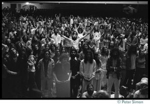 Audience in the Winterland Ballroom raising their arms in ecstasy, listening to Amazing Grace during the Ram Dass 'marathon'