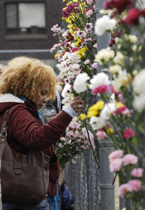 Justice for Jason rally at UMass Amherst: UMass graduate student Iris Jacob, places a flower on a fence near the dormitory of Jason Vassell