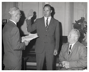 City Clerk Walter J. Malloy administering oath to unidentified man as Mayor John F. Collins watches