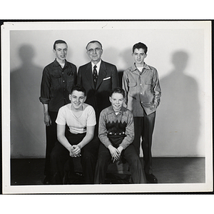 An older man in suit and four Boys' Club members pose for a group picture