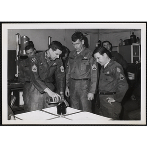 Several men wearing U.S. Army uniform developing photographs at a photographic laboratory
