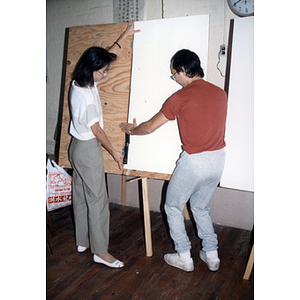 Two Chinese Progressive Association members prepare a poster for the August Moon Festival