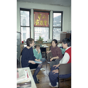 Lydia Lowe chats with a woman and two men at the Chinese Progressive Association's celebration of the Chinese New Year