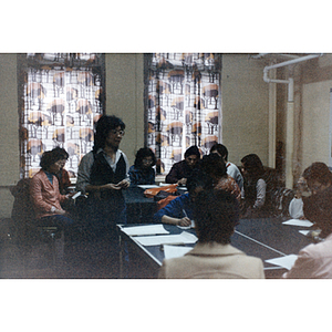 Students work at tables on their English, while the teacher watches