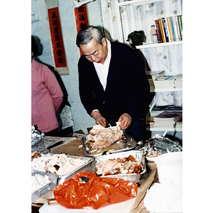 Man carves a turkey at a Thanksgiving dinner and celebration