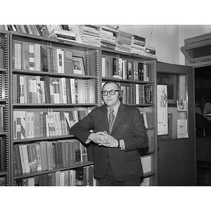 Professor Raymond Robinson standing by a bookcase