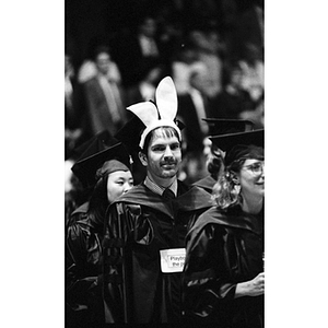 A graduating law student wears bunny ears in line to receive his diploma