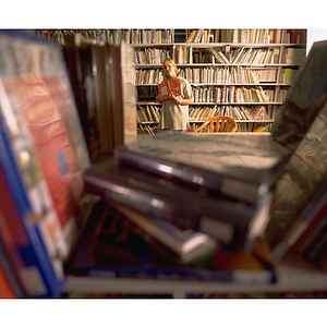 A young woman holds a copy of "Green Eggs and Ham" by Dr. Seuss on her co-op in the children's section of a public library