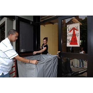 A woman holds open the door for Odalis David Polanco during move-in