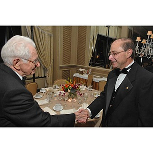 President Aoun, right, shaking hands with a guest at a Huntington Society Dinner