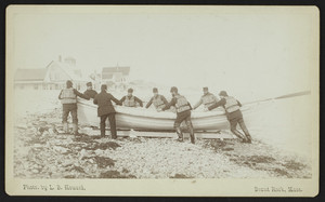 Life-saving team standing around a surfboat on the beach, Marshfield, Mass., undated
