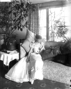 Portrait of Miss Lulu Palfrey, reclining on a couch in the morning room, facing front, looking down to the right, Arthur Little House, 2 Raleigh Street, Boston, Mass., undated
