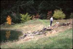 Sandi Sommer's brother Wayne with Maya dog by pond and waterfall