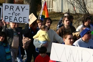 Anti-war protesters, one carrying and infant, and sign reading 'Pray for peace': rally and march against the Iraq War