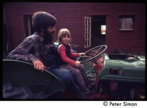 Father and child on a tractor, Tree Frog Farm commune