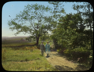 Man and woman on dirt road in meadow