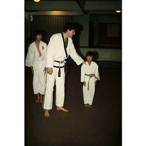 Man talking to young boy during a martial arts class